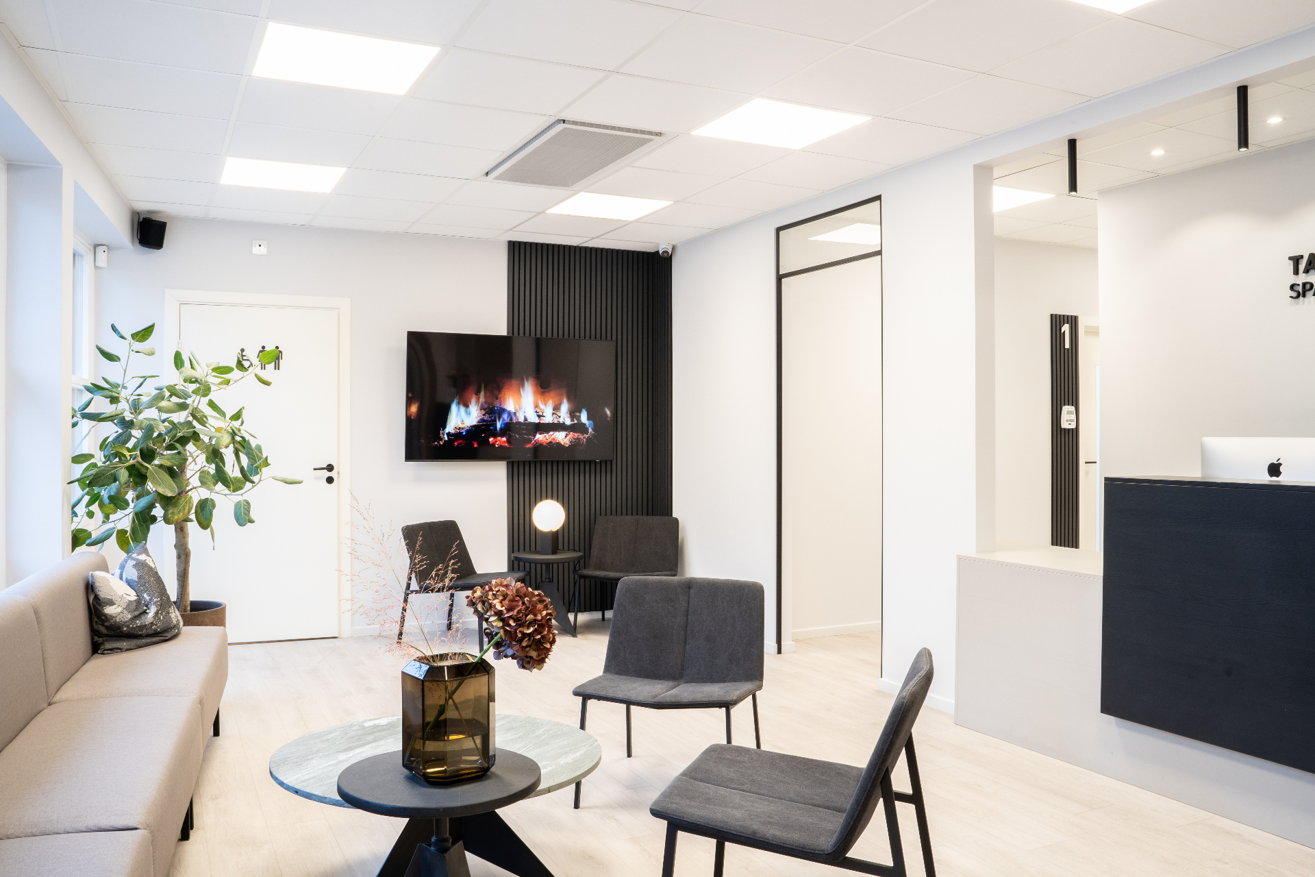 Väntrum med soffa, brasa och växter